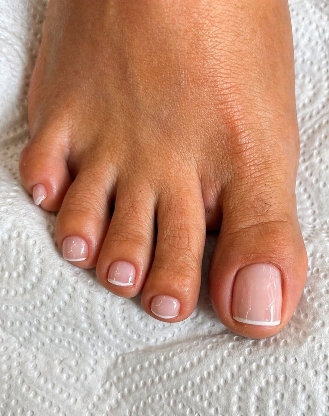 Pedicure com francesinha branca e acabamento impecável